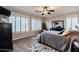 Bedroom with multiple windows, shutters, floral rugs, ceiling fan, and a cushioned bench at 3053 S Canfield --, Mesa, AZ 85212