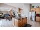 Open kitchen with large island, stainless steel refrigerator, and view to the dining and living spaces at 3053 S Canfield --, Mesa, AZ 85212