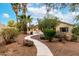 Lush backyard landscaping with rock-lined walking paths, mature trees, and desert accents at 3700 N 149Th Ln, Goodyear, AZ 85395