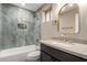 Stylish bathroom featuring a tub and shower combo with unique tile, a modern vanity, and elegant fixtures at 3700 N 149Th Ln, Goodyear, AZ 85395