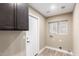 Functional mud room with dark cabinetry, white door, and laundry hookups near window at 3700 N 149Th Ln, Goodyear, AZ 85395