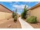 Spacious side yard with desert landscaping and a walkway dividing the house from the lot line at 3700 N 149Th Ln, Goodyear, AZ 85395