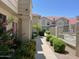 Condos with red roofs are nicely landscaped along a sidewalk in this exterior view at 3930 W Monterey St # 115, Chandler, AZ 85226