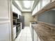 Efficient galley kitchen with stainless steel appliances, white cabinetry and tile flooring at 3930 W Monterey St # 115, Chandler, AZ 85226