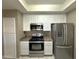 Efficient kitchen showcasing stainless steel appliances, white cabinetry, and tile flooring at 3930 W Monterey St # 115, Chandler, AZ 85226