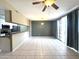 Open living room layout with tile flooring, ceiling fan, and a kitchen view with a breakfast bar at 3930 W Monterey St # 115, Chandler, AZ 85226