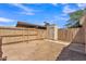 Backyard featuring a wood fence and gate with blue skies, shed, and covered area at 4836 W Rose Ln, Glendale, AZ 85301
