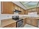 Eat-in kitchen showcasing stainless steel range and complementing wood cabinets at 4836 W Rose Ln, Glendale, AZ 85301