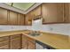 Traditional kitchen featuring wood cabinets, stainless steel dishwasher, and sink at 4836 W Rose Ln, Glendale, AZ 85301