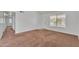 An empty living room featuring neutral paint, carpet and access to another room at 4836 W Rose Ln, Glendale, AZ 85301