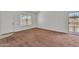 An empty living room featuring neutral paint, carpet, window with security bars and front door at 4836 W Rose Ln, Glendale, AZ 85301
