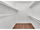 An all-white walk-in closet with brown carpet and multiple shelves for ample storage at 4836 W Rose Ln, Glendale, AZ 85301