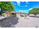 A home's low-maintenance backyard featuring rock landscaping, a fire pit and covered patio, perfect for relaxation at 6041 E Colby St, Mesa, AZ 85205