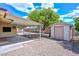 Backyard with a covered patio, storage shed, rock landscaping, and citrus tree for a serene outdoor experience at 6041 E Colby St, Mesa, AZ 85205