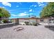 Low-maintenance backyard showcasing rock landscaping, a fire pit, and a covered patio for outdoor enjoyment at 6041 E Colby St, Mesa, AZ 85205