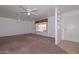 Comfortable living area includes neutral carpet, a ceiling fan, and a front-facing window at 6041 E Colby St, Mesa, AZ 85205