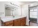 Bathroom featuring wood cabinets, neutral countertops, updated sink and a glass-enclosed shower at 617 W Gibraltar Ln, Phoenix, AZ 85023