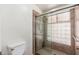 Updated bathroom shower with glass-block window, tiled walls and glass door at 617 W Gibraltar Ln, Phoenix, AZ 85023