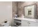 Stylish powder room with decorative wall tiles, white vanity, and a framed mirror at 7343 E Casitas Del Rio Dr, Scottsdale, AZ 85255