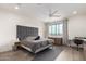 Serene bedroom with a gray upholstered bed, a ceiling fan, and a bright window, creating a peaceful ambiance at 7343 E Casitas Del Rio Dr, Scottsdale, AZ 85255