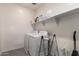 Functional laundry room with white washer and dryer, shelving, and neutral color palette at 7343 E Casitas Del Rio Dr, Scottsdale, AZ 85255