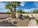 Backyard featuring a stone patio set, fire pit, mature trees, and a shed for extra storage at 8222 E Sheridan St, Scottsdale, AZ 85257