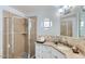 Bathroom with glass enclosed shower, round window, and granite counters at 8222 E Sheridan St, Scottsdale, AZ 85257