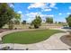 Turf backyard featuring lovely landscaping, mature trees, and travertine pavers with view of the golf course at 8542 W Rosemonte Dr, Peoria, AZ 85382