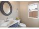 Powder room featuring a white vanity with blue accents, decorative wall mirror and natural light at 8542 W Rosemonte Dr, Peoria, AZ 85382