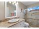 Bright bathroom featuring a single sink, modern fixtures, and glass-enclosed shower with decorative tile accents at 8542 W Rosemonte Dr, Peoria, AZ 85382