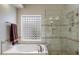 Bathroom featuring a glass door shower and a jacuzzi tub under a unique block window at 8542 W Rosemonte Dr, Peoria, AZ 85382