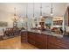 Open concept kitchen with granite counters, rich wood cabinetry, and modern lighting at 8542 W Rosemonte Dr, Peoria, AZ 85382