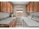 A functional laundry room with ample counter space, upper cabinets, and modern washer and dryer units at 8542 W Rosemonte Dr, Peoria, AZ 85382