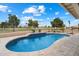 A refreshing in-ground pool with a tiled edge and travertine surround, overlooking a lush green golf course at 8542 W Rosemonte Dr, Peoria, AZ 85382