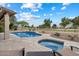 In-ground pool, jacuzzi and travertine tile highlight this backyard retreat with beautifully landscaped plants at 8542 W Rosemonte Dr, Peoria, AZ 85382