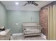 Cozy bedroom featuring a crib, brick accent wall, and neutral carpet at 921 S Val Vista Dr # 28, Mesa, AZ 85204