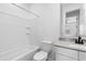 Well-lit bathroom features a white tub with shower, commode, vanity with sink, and a framed mirror at 9728 E Twinkle Ave, Mesa, AZ 85212