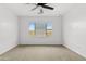 Spacious bedroom with neutral carpet, a ceiling fan, and a view of the outdoors at 9728 E Twinkle Ave, Mesa, AZ 85212