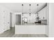 Open kitchen layout with stainless steel appliances, white cabinets, and stylish pendant lighting at 9728 E Twinkle Ave, Mesa, AZ 85212
