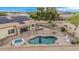 A peaceful backyard featuring a pool, spa, patio, firepit, putting green, and solar panels on the home at 11511 E Chestnut Ct, Chandler, AZ 85249