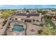 A luxurious backyard featuring a pool, spa, fire pit, patio seating, and solar panels on the home at 11511 E Chestnut Ct, Chandler, AZ 85249
