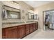 Bathroom vanity with double sinks, granite countertop, wooden cabinets, and tiled floors at 11511 E Chestnut Ct, Chandler, AZ 85249