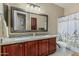 Bathroom features a double sink vanity with granite countertops, a large mirror, and shower with curtain at 11511 E Chestnut Ct, Chandler, AZ 85249
