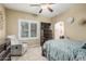 Cozy bedroom featuring a window, a ceiling fan, a TV, and neutral walls at 11511 E Chestnut Ct, Chandler, AZ 85249