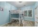 Blue bedroom features a white ladder bed with a desk, and a large window with a chandelier at 11511 E Chestnut Ct, Chandler, AZ 85249