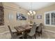 Charming dining room with a rustic wood table, modern chandelier, and plantation shutters at 11511 E Chestnut Ct, Chandler, AZ 85249