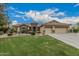 Charming home with three-car garage, desert landscaping, and lush green lawn at 11511 E Chestnut Ct, Chandler, AZ 85249