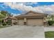 Three-car garage with carriage doors and stone accents, lush landscaping, and desert surroundings at 11511 E Chestnut Ct, Chandler, AZ 85249