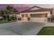 Three-car garage with carriage doors and stone accents, complemented by desert landscaping at 11511 E Chestnut Ct, Chandler, AZ 85249