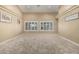 Spacious living room with neutral carpet, plantation shutters, and ample natural light at 11511 E Chestnut Ct, Chandler, AZ 85249